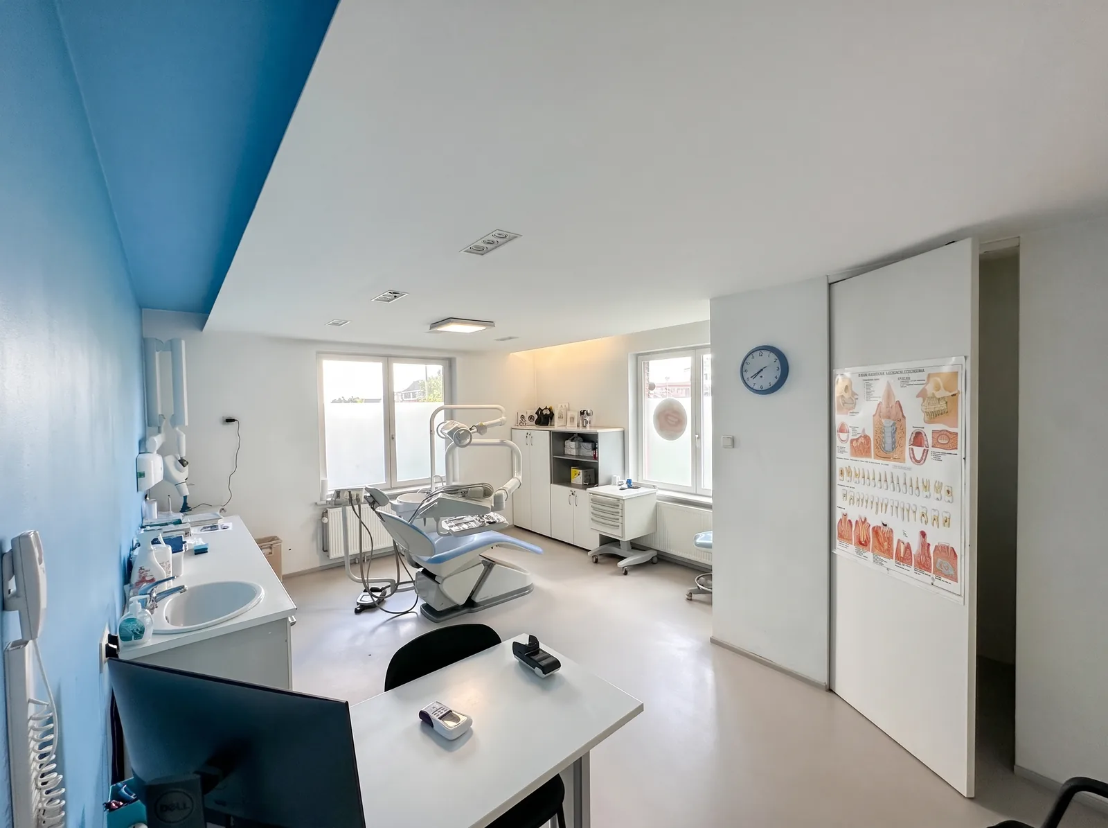 Salle de soins du cabinet dentaire Dentoker à Laeken, avec son fauteuil et ses grandes fenêtres